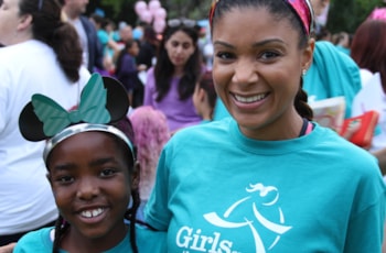 Girls on the Run coach and participant both smile